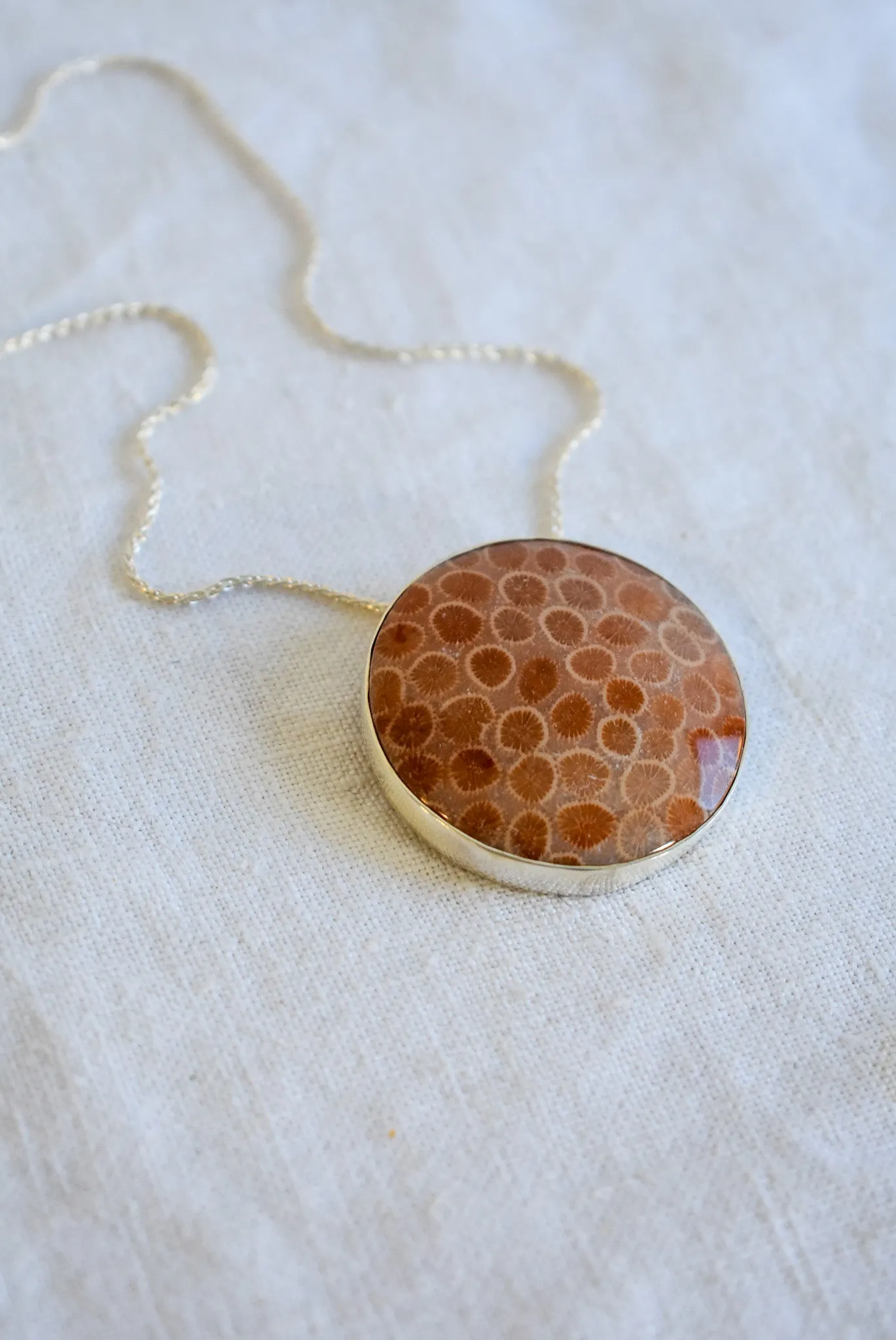 Fossilized coral set in silver snake chain necklace