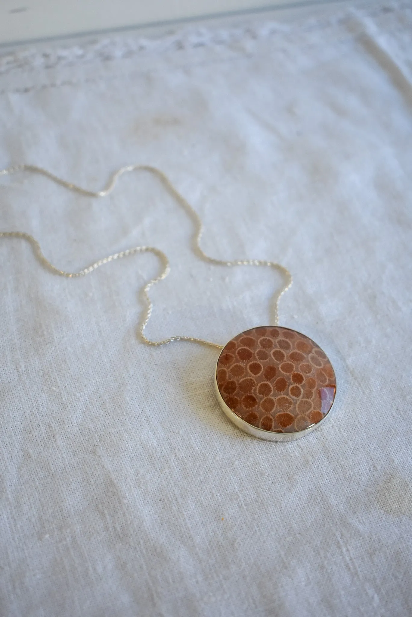 Fossilized coral set in silver snake chain necklace